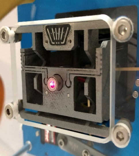 3D printed XY-stage with embedded sensor and external actuator. A laser pointer is integrated to the moving platform to illustrate the capacity of the demonstrator to power a device through flexure blades.