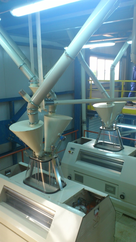 Plastic buffer tank on top of roller mill machines.