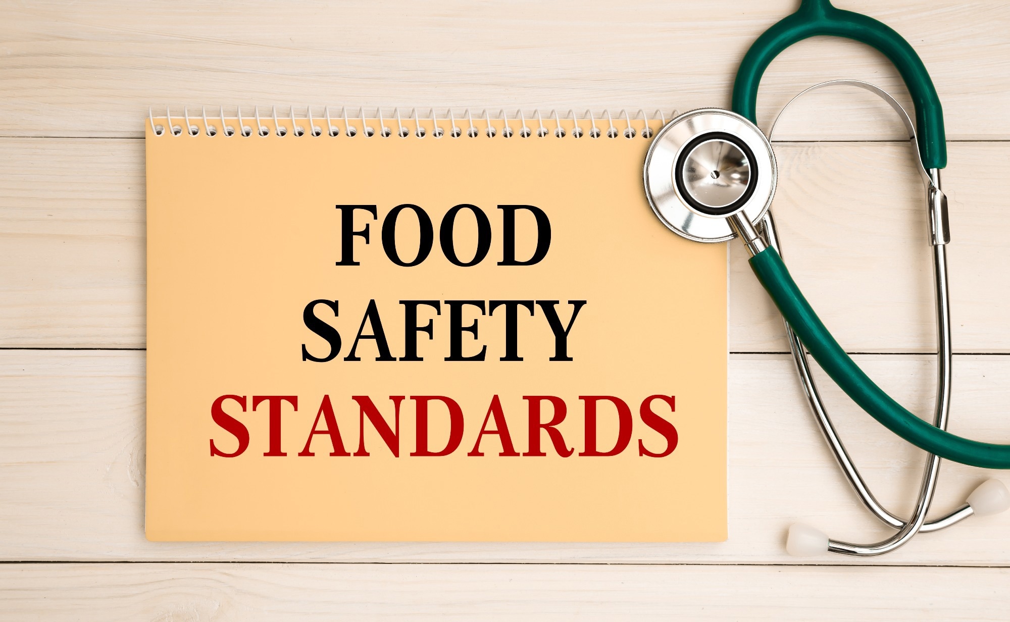 Notepad with text Food Safety Standards on the office desk and stethoscope.