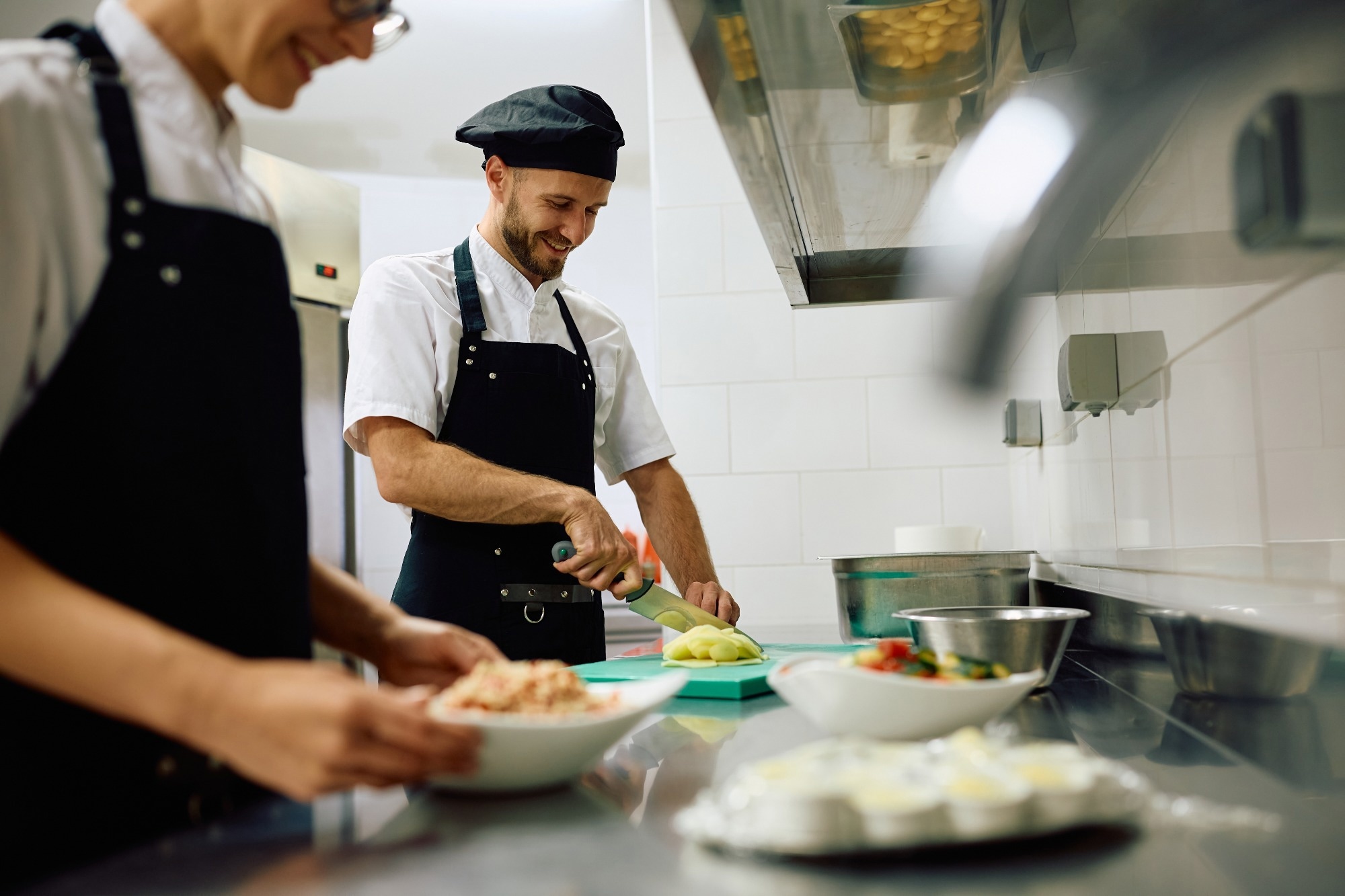 A male chef preparing food in a restaurant.