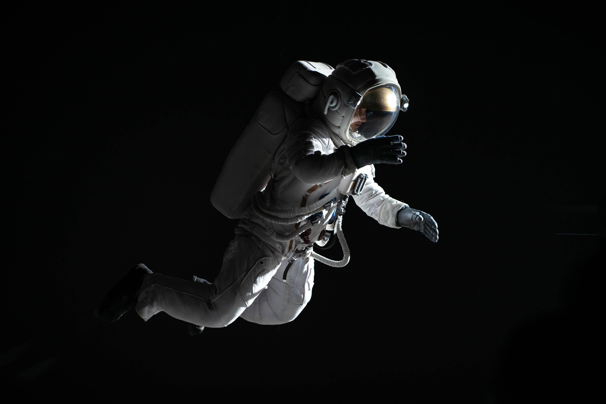 Astronaut in white suit in space with dark background.