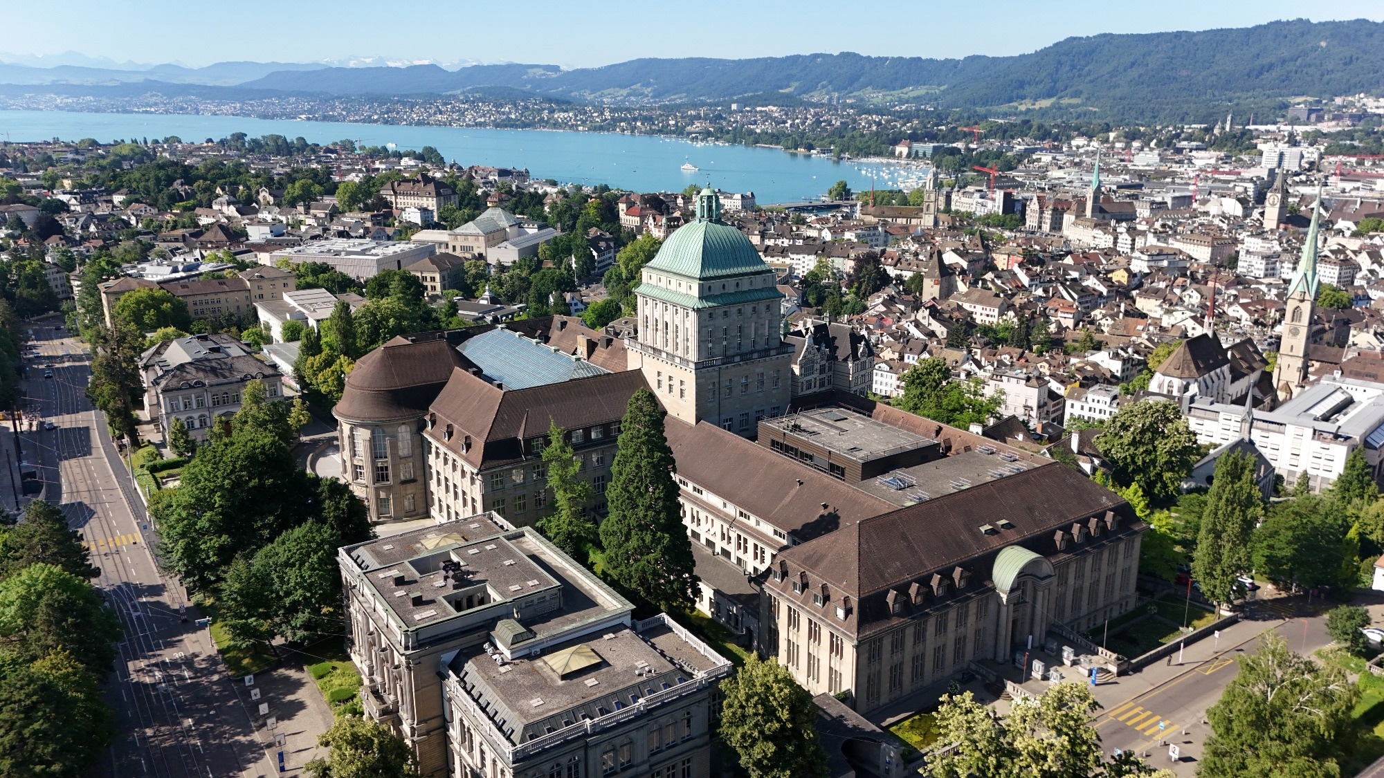 A birds eye view photo of a university building in Zurich, surrounded by buildings and near the sea.
