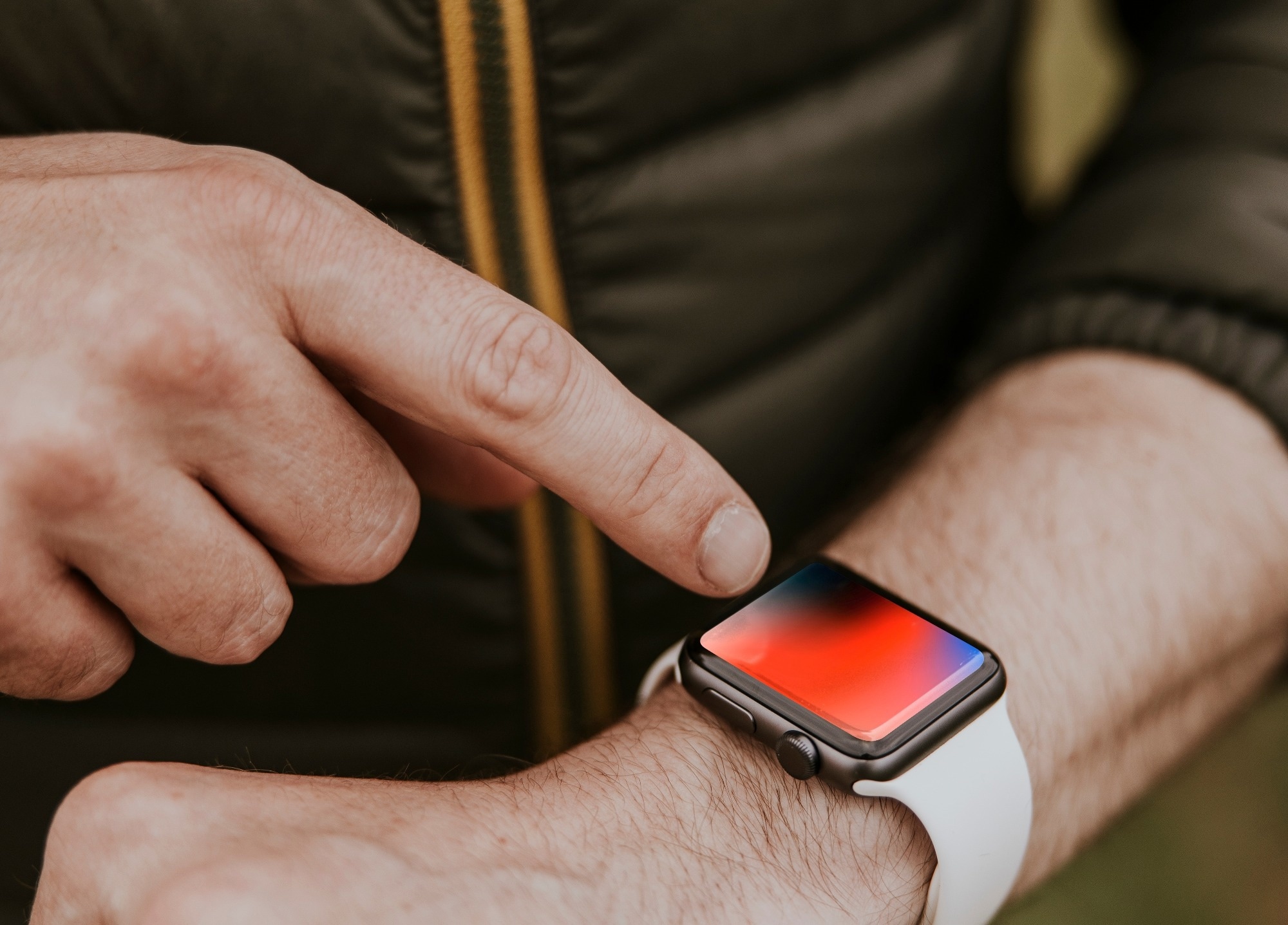 A man goes to tap his smart watch before a trail.