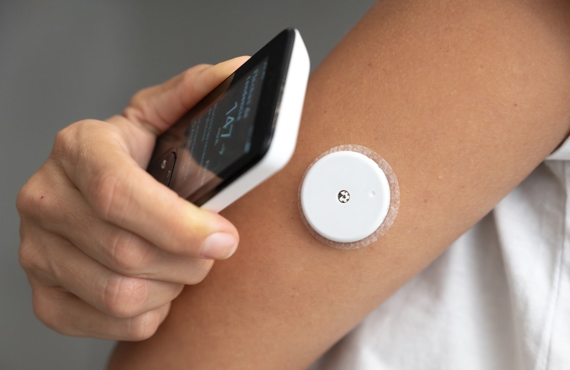 Patient applying continuous glucose monitoring sensor and checking blood sugar level