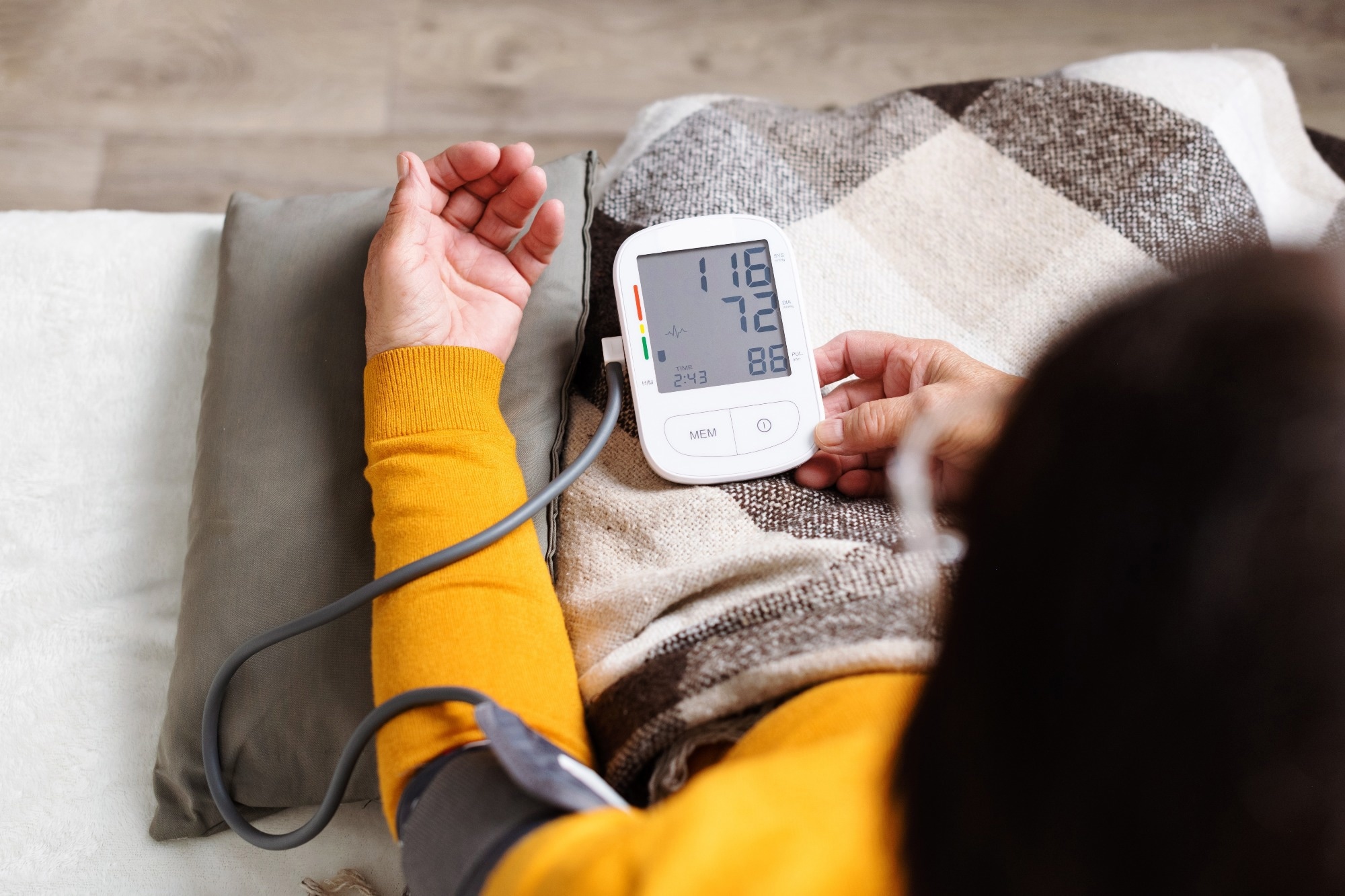 woman measuring her blood pressure. Retired uses medicine digital device tonometer for control health at home