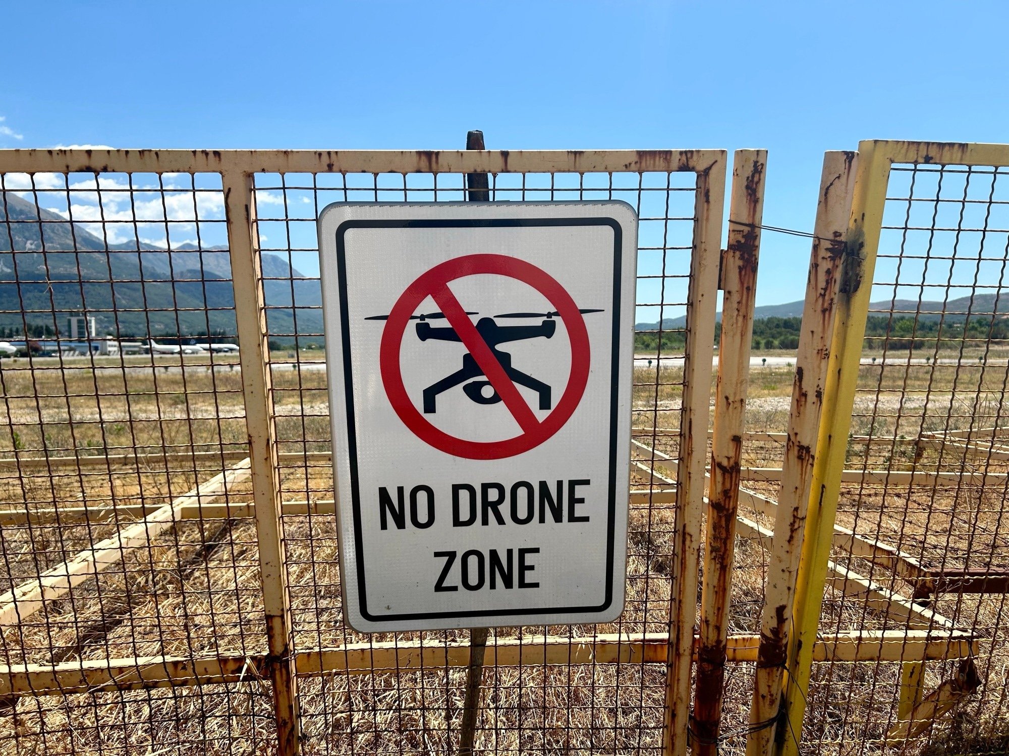 Fence in arid landscape with a sign saying
