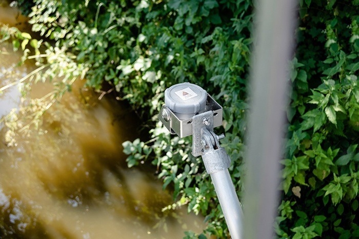 A VEGA Water radar transmitter seen in nature surrounded by foliage.