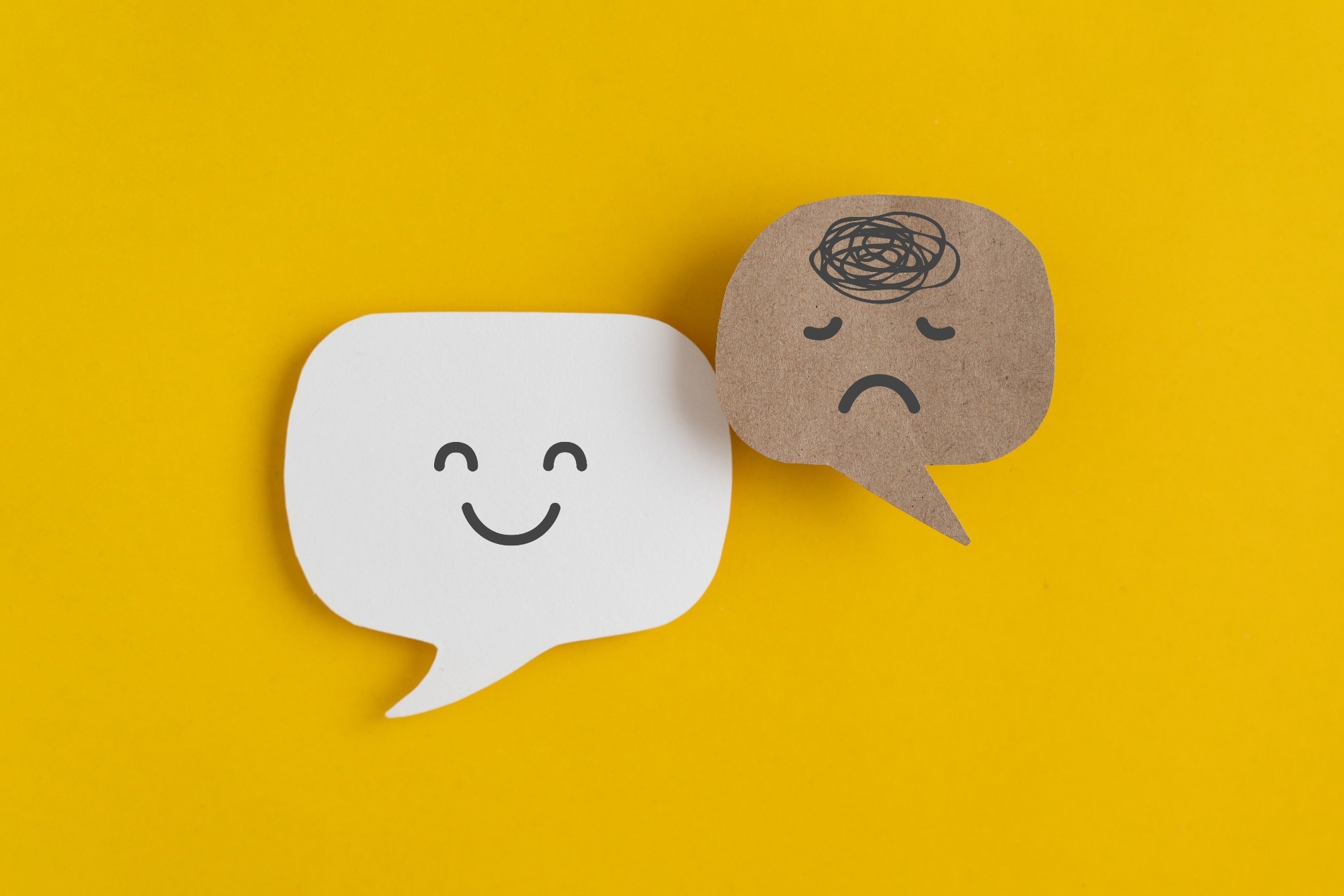 World mental health day, Alzheimer and Psychology concept. Tangle of thoughts and happy face on real speech bubble with yellow background.