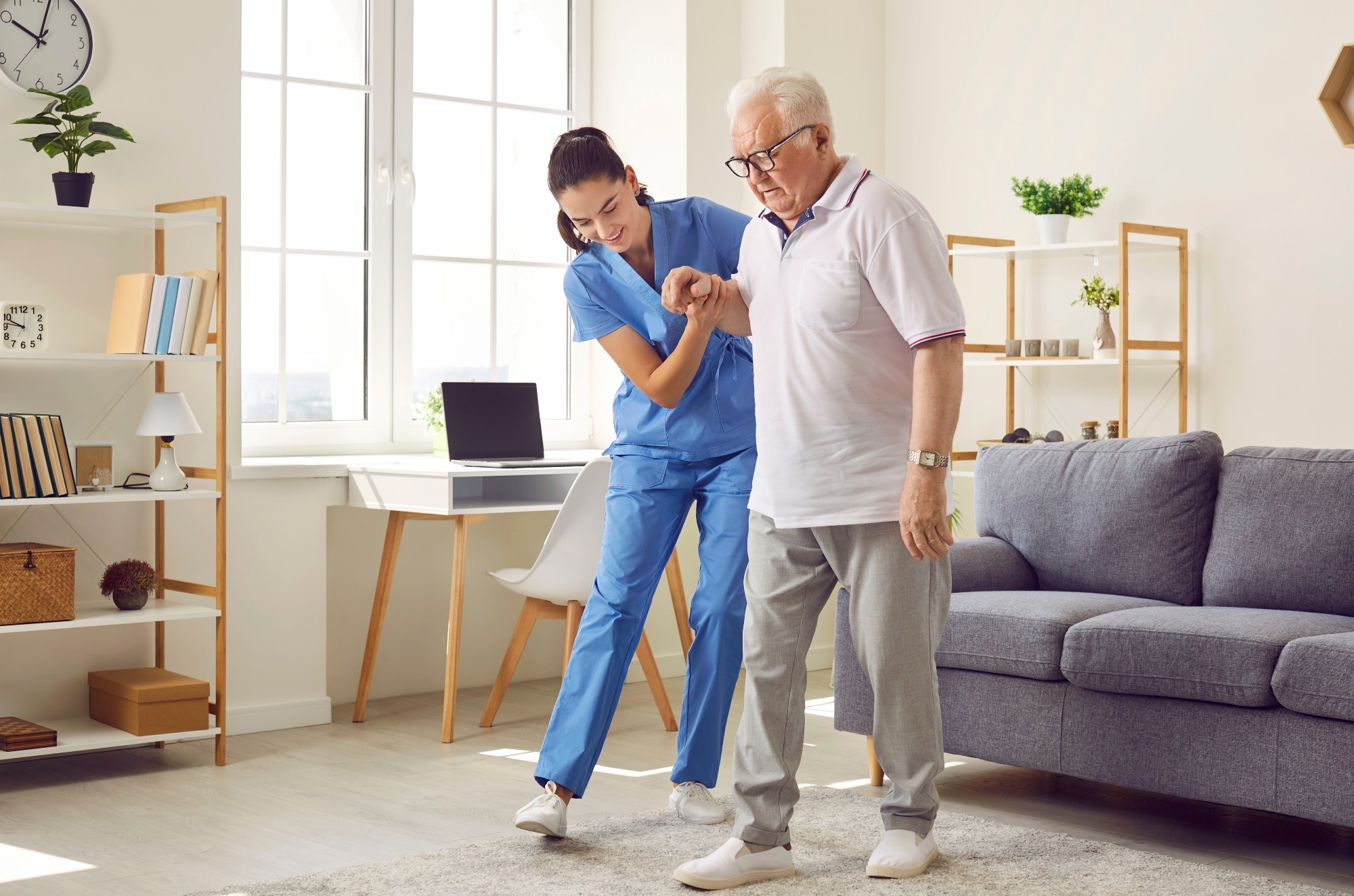 Young nurse helping elderly man walk