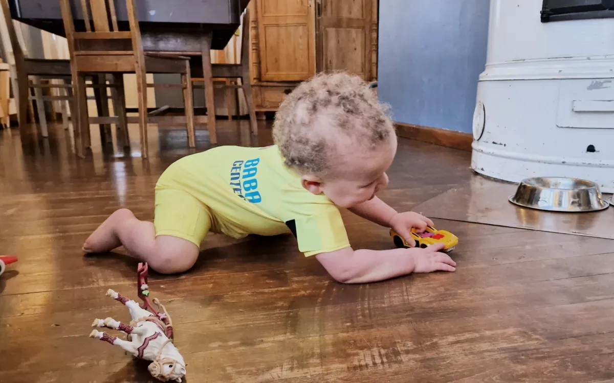 A child playing in a smart jumpsuit.