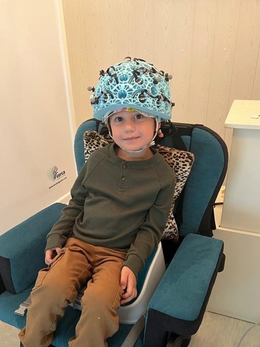 Photo of a young boy in wearable MEG scanner.