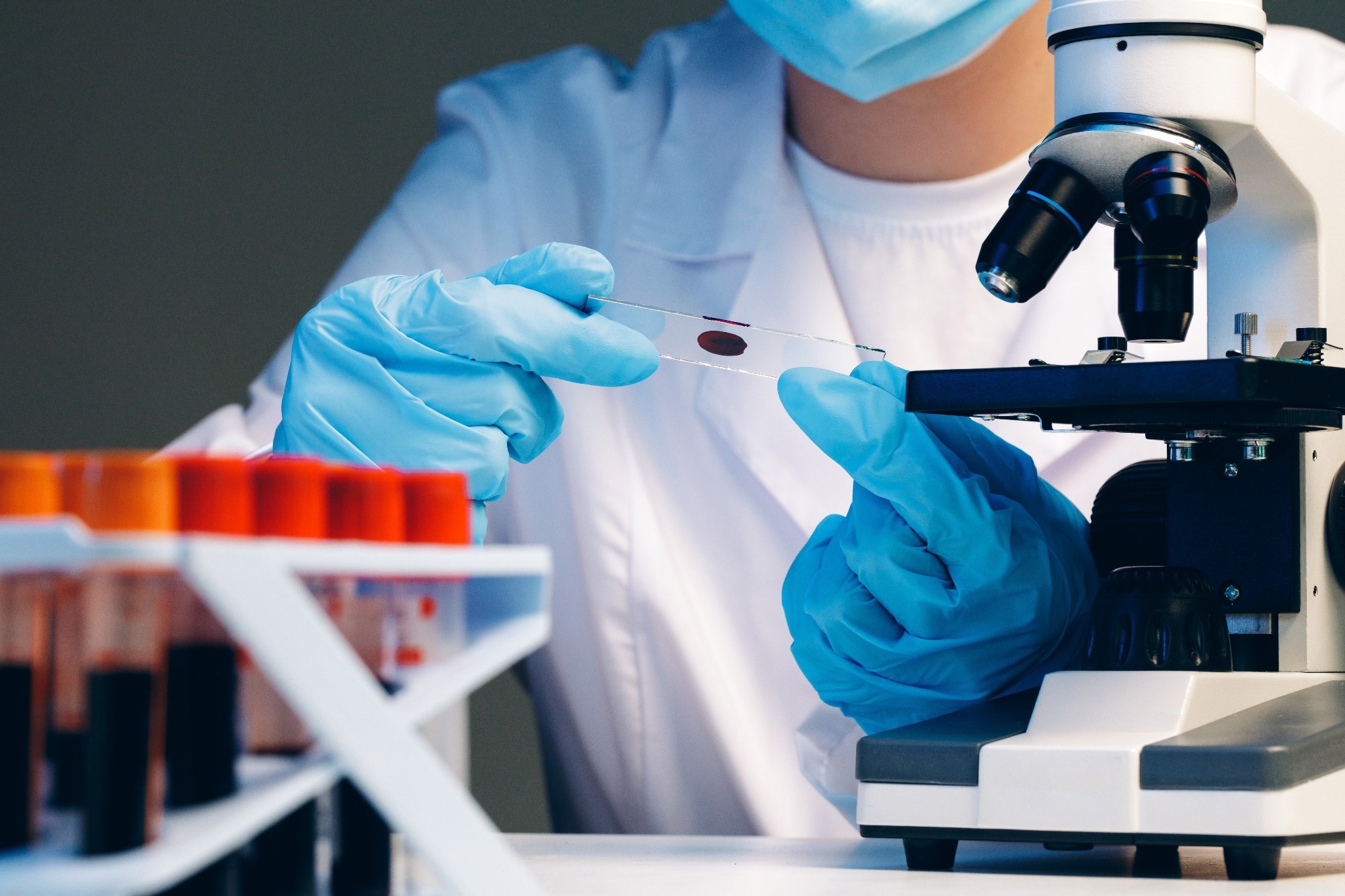 Lab technician observing blood spots for medical testing.