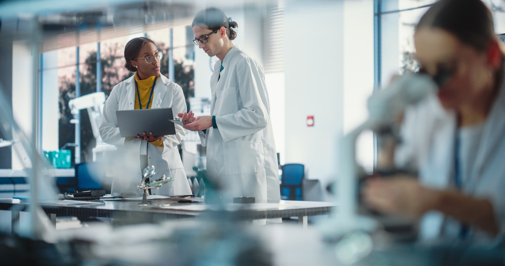 A group of engineers discussing lab processes by a production lab.