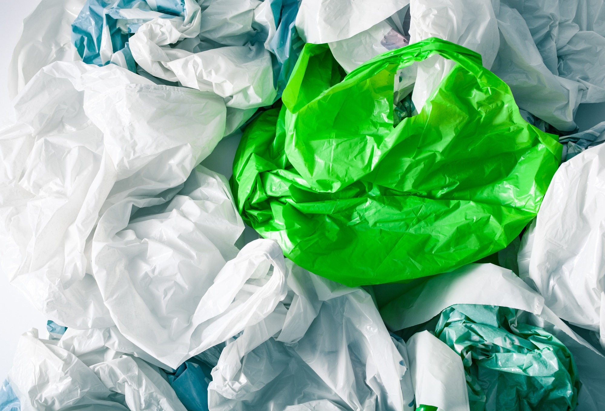 White, blue and green plastic bags scrunched up together.