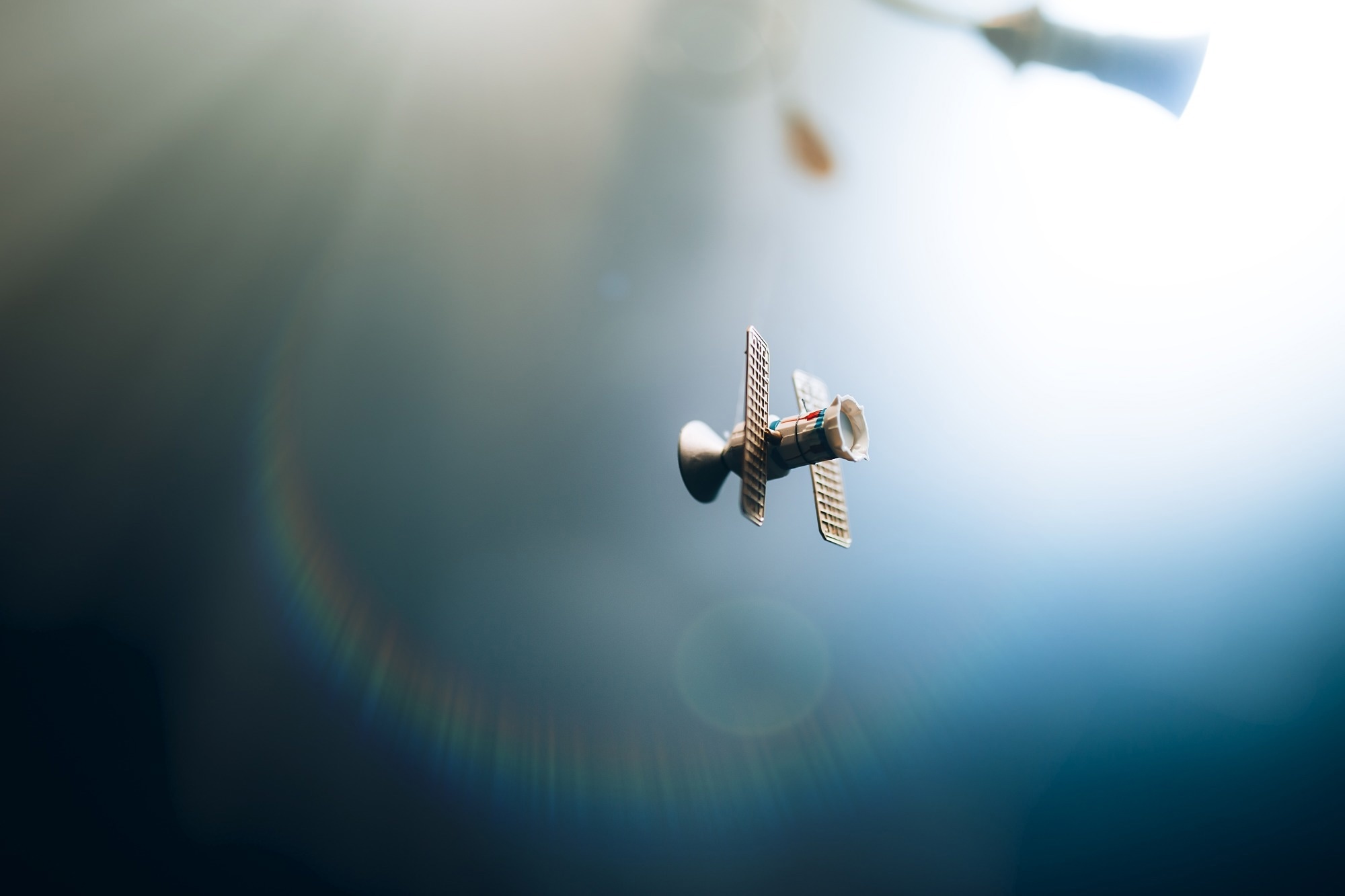 A satellite in orbit with blurred blue light.