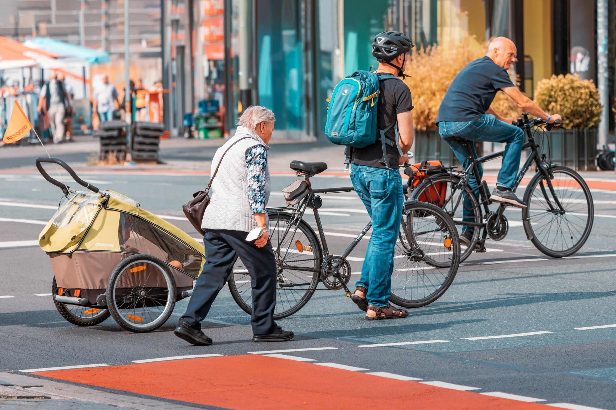 cyclists and pedestrians cross a road at a crossing.