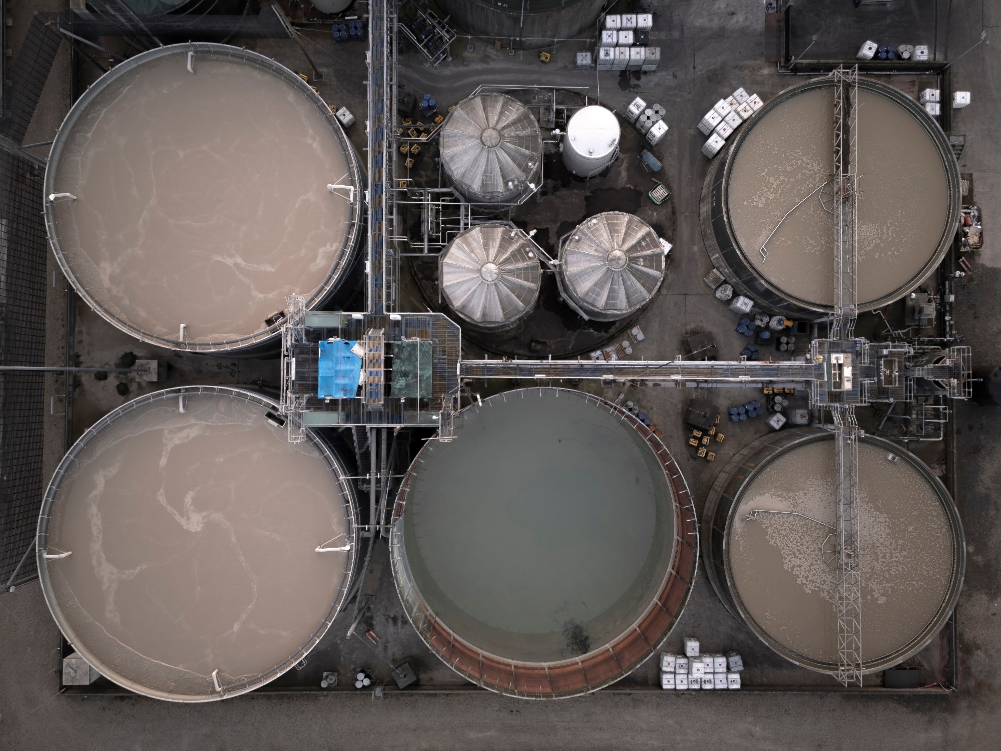 Aerial drone image of a sewage sludge plant showing 5 tanks from above.
