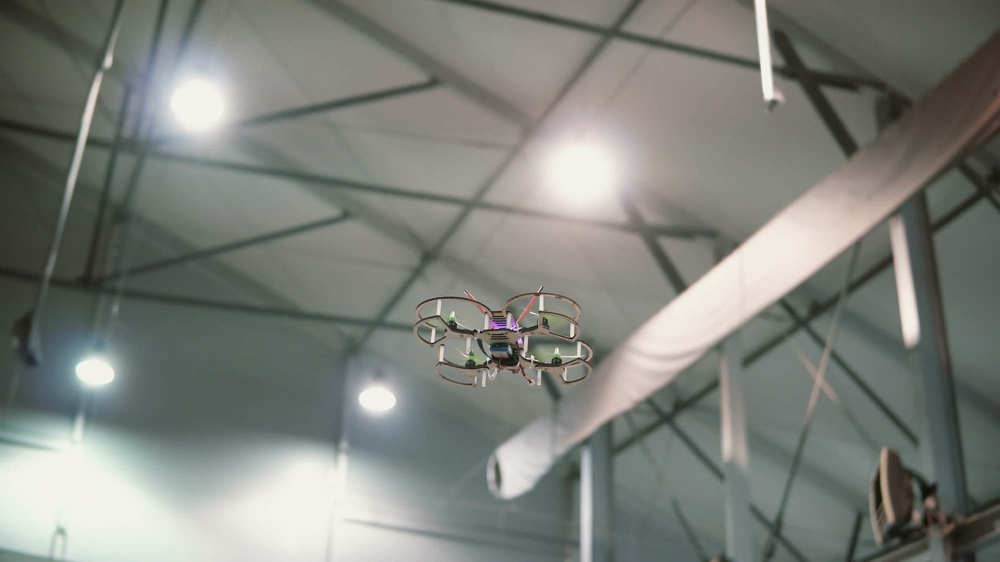 Small copter flies under the ceiling indoors. Drone flying over the floor.