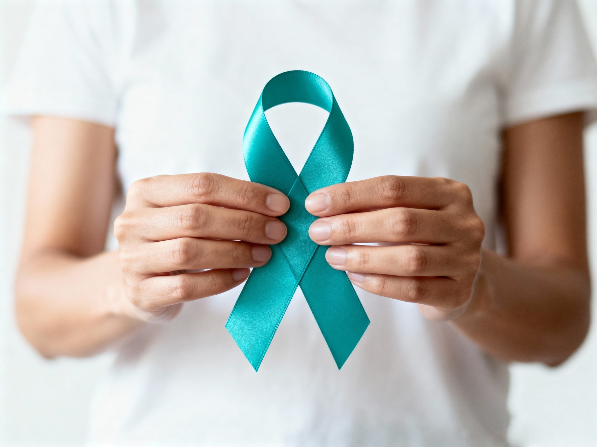 Woman holding a teal ovarian cancer awareness ribbon